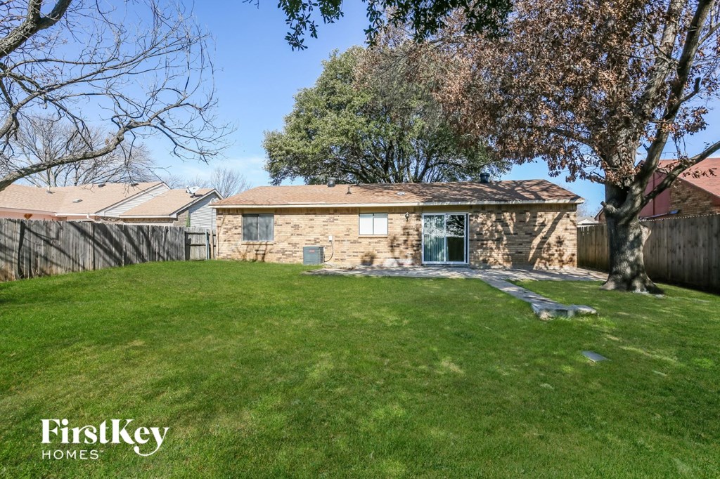 a stone house with a yard and a tree