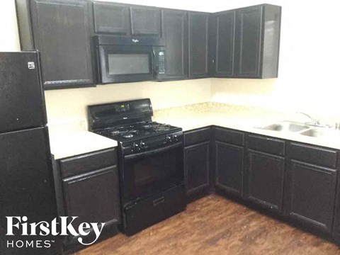 A black kitchen with a FirstKey Homes logo.