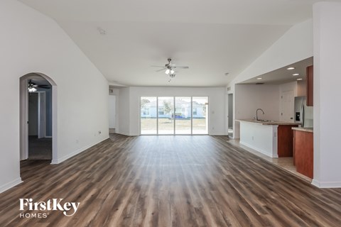 A spacious room with wooden flooring and a ceiling fan.