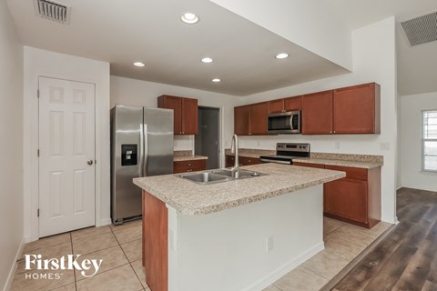 A kitchen with a granite countertop and stainless steel appliances.