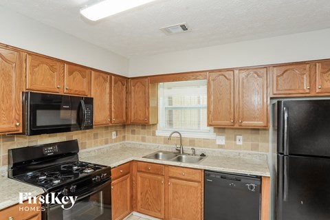 A kitchen with wooden cabinets and black appliances.