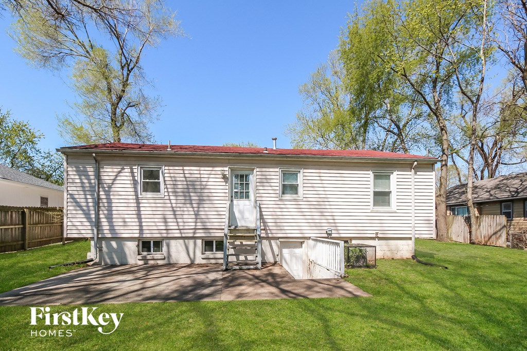a small white house with a red roof on a lawn
