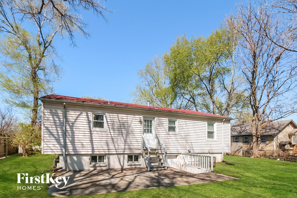 a small white house with a red roof on a lawn