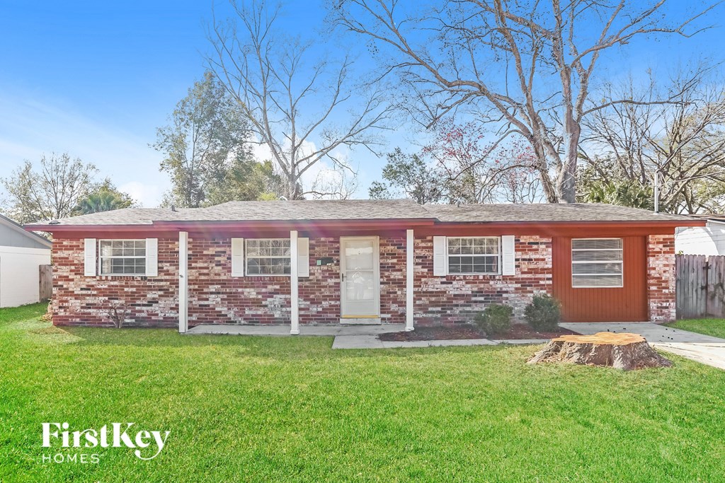 A brick house with a white door and windows is for sale.