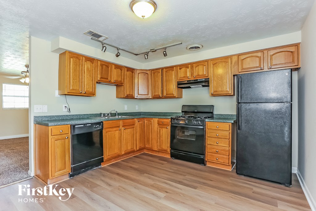 A kitchen with wooden cabinets and black appliances.