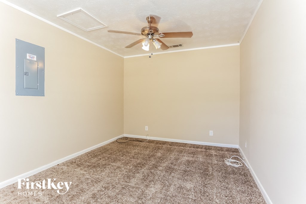 A room with a ceiling fan and a carpeted floor.