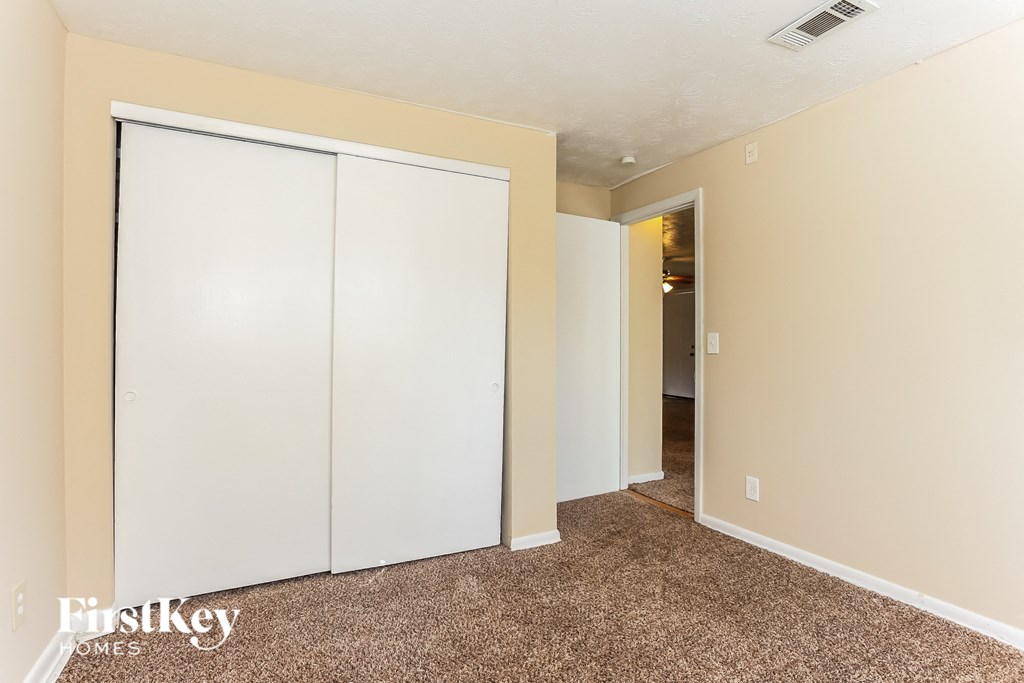 A room with a carpeted floor and a white door.