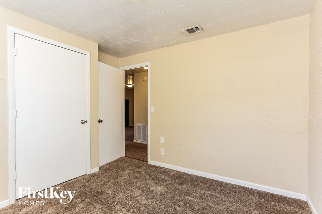 A room with a carpeted floor and a white door.