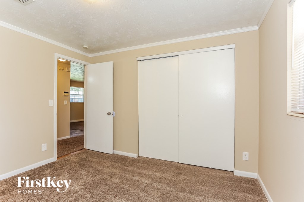 A room with a carpeted floor and a white door.