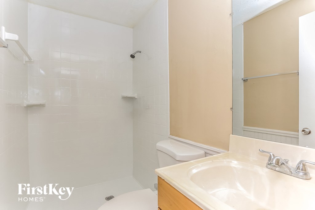 A bathroom with a sink, toilet and shower.