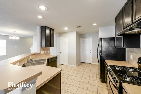 A kitchen with a stove top oven and a sink.
