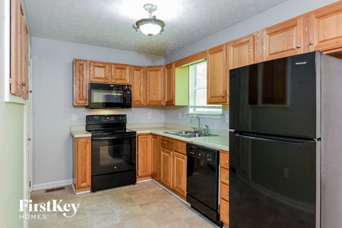 A kitchen with wooden cabinets and black appliances.