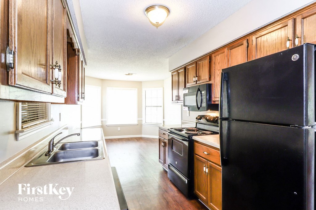 a kitchen with black appliances and wooden cabinets