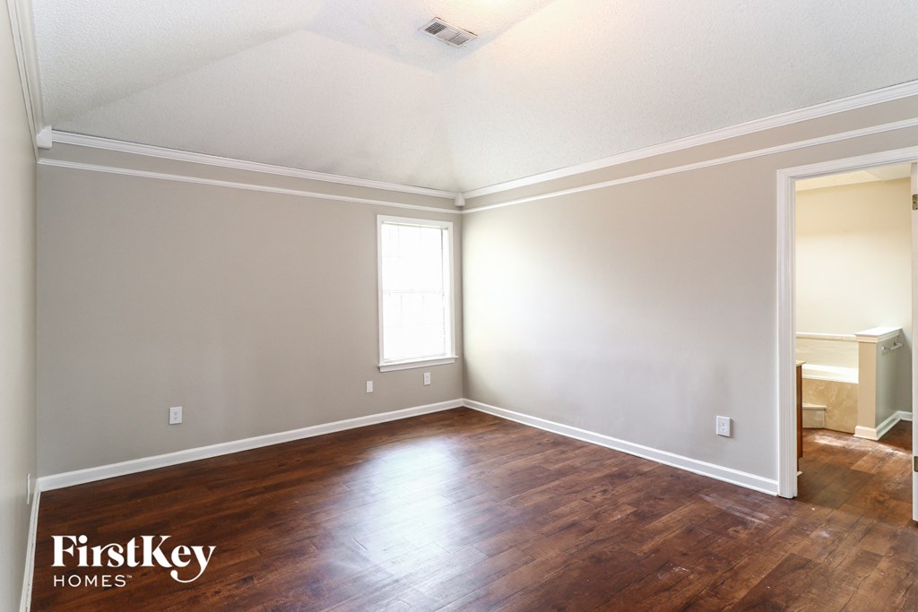 the living room of a house with wood floors and white walls