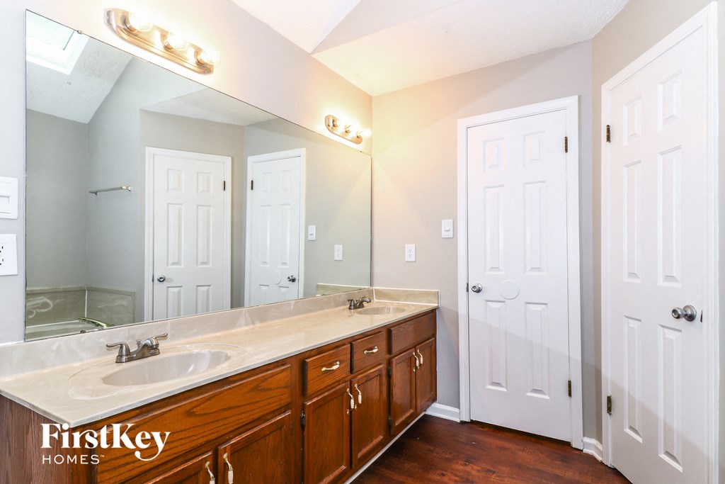 the master bathroom has a large mirror and a large sink