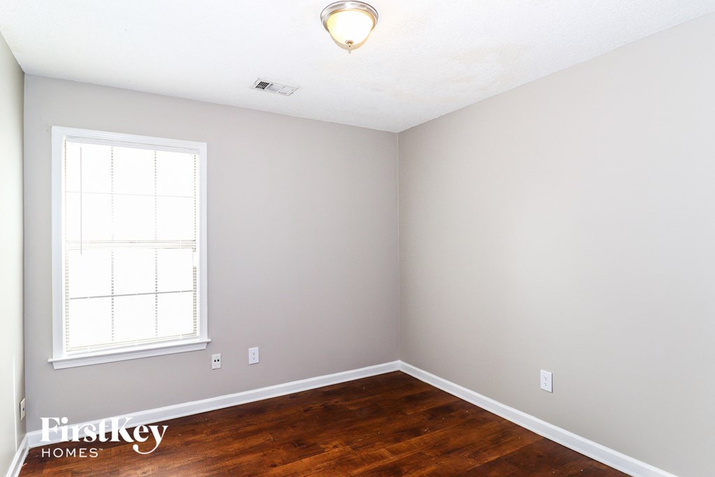 a room with wood floors and a window and a white ceiling
