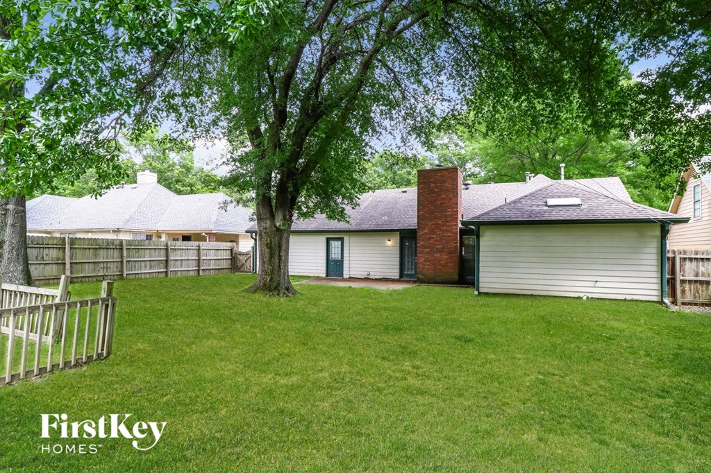 the backyard of a house with a yard and a fence