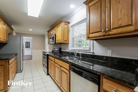 a kitchen with wooden cabinets and black countertops and a sink
