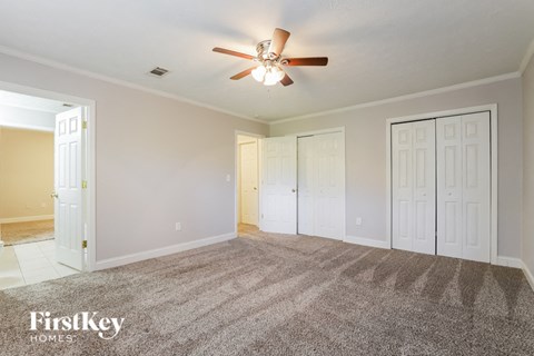 a living room with carpet and a ceiling fan