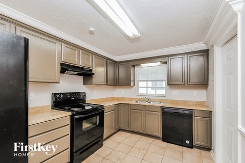 A kitchen with a black fridge and black dishwasher.