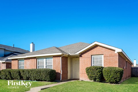 a brick house with a yard and a blue sky