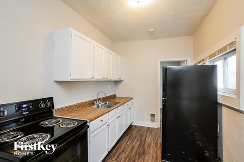 a kitchen with white cabinets and black appliances and a black refrigerator