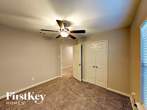 a bedroom with a ceiling fan and a closet