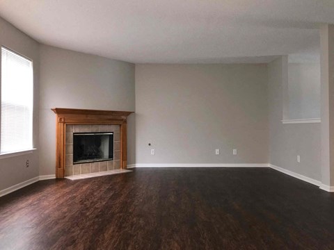 a living room with a fireplace and wooden floors