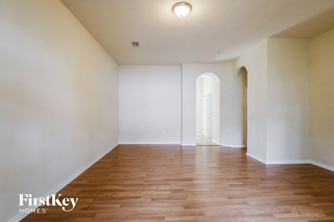an empty living room with white walls and wood floors