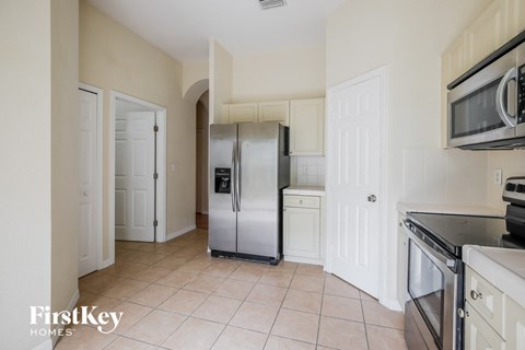 a kitchen with white cabinets and a stainless steel refrigerator