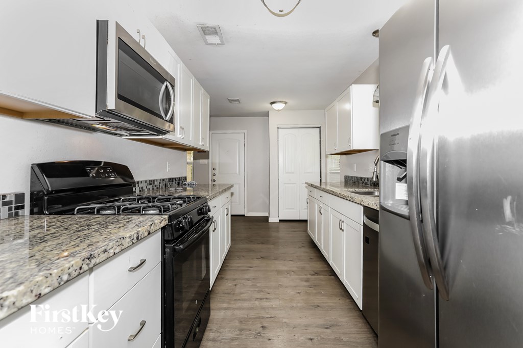 A kitchen with a stove top oven and a refrigerator.