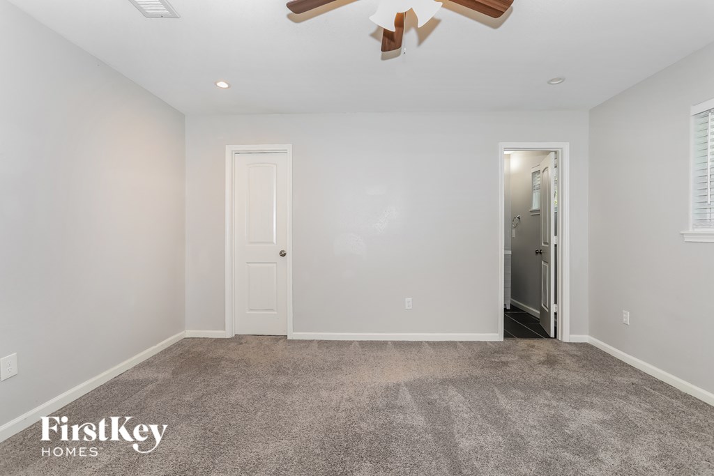 A room with a carpeted floor and a door leading to another room.