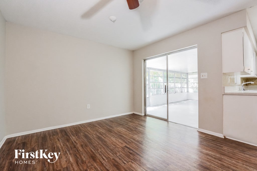 an empty living room with wood flooring and a sliding glass door