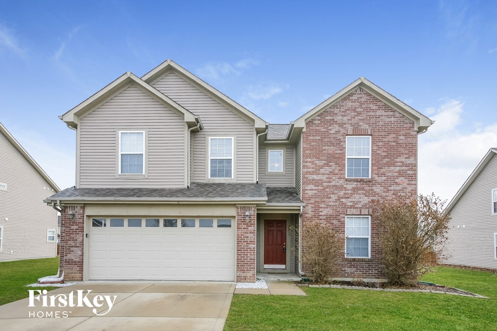 A two-story house with a garage is for sale.