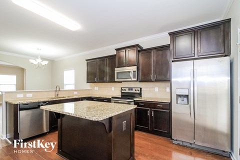A kitchen with a granite counter top and stainless steel appliances.