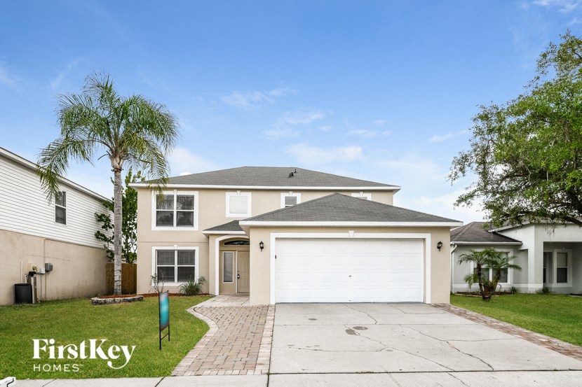 a house with a white garage door and a palm tree