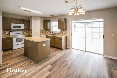 an open kitchen with stainless steel appliances and wood flooring