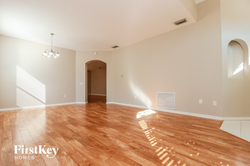 a living room with a hardwood floor and white walls