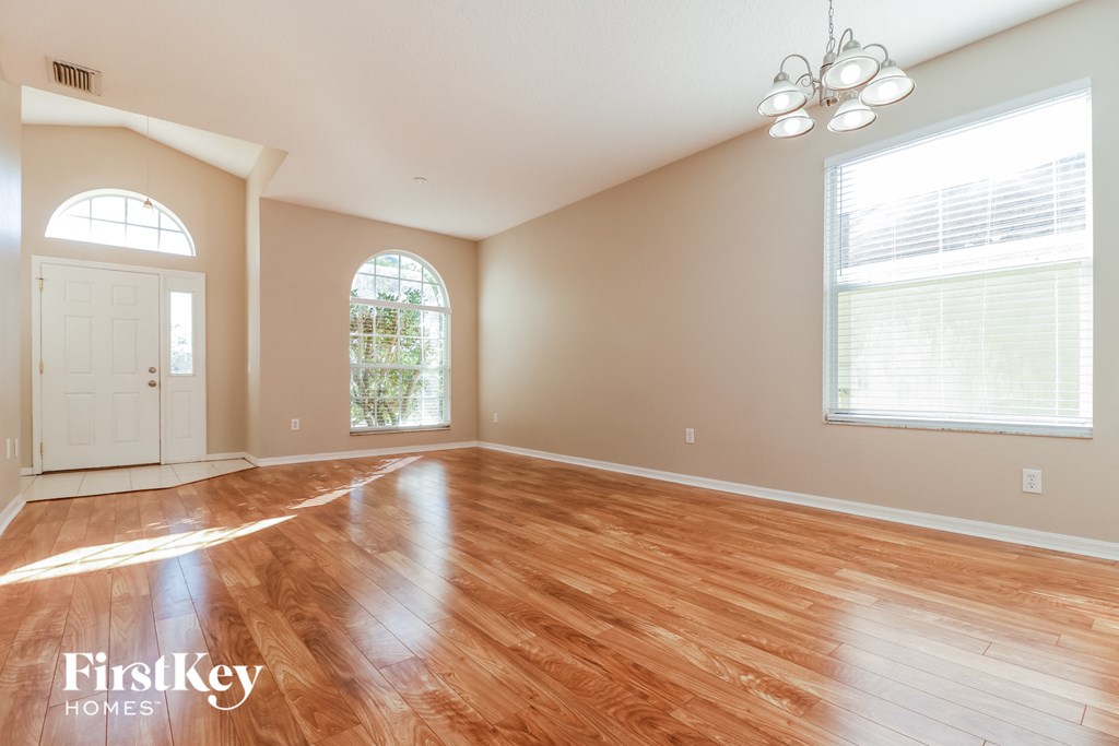 an empty living room with wood floors and a white door