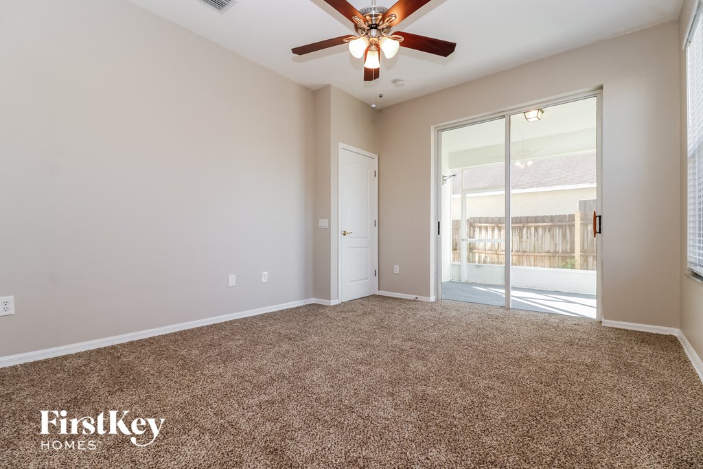 the living room of an empty house with a ceiling fan