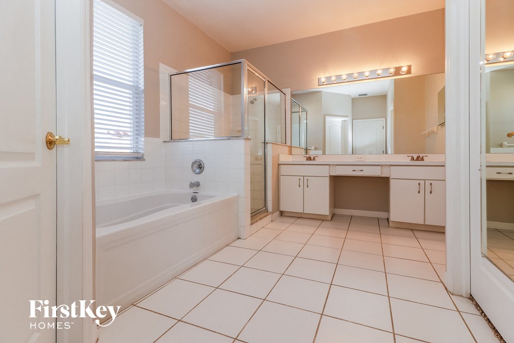 a bathroom with a tub and a sink and a mirror