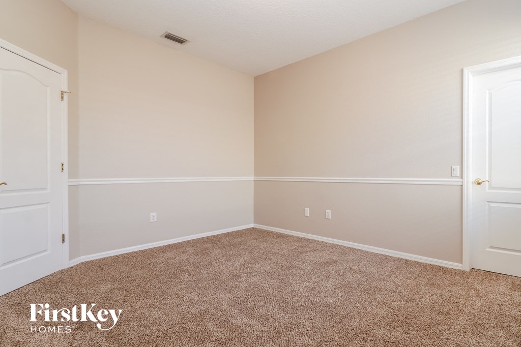 a bedroom with a carpeted floor and white walls