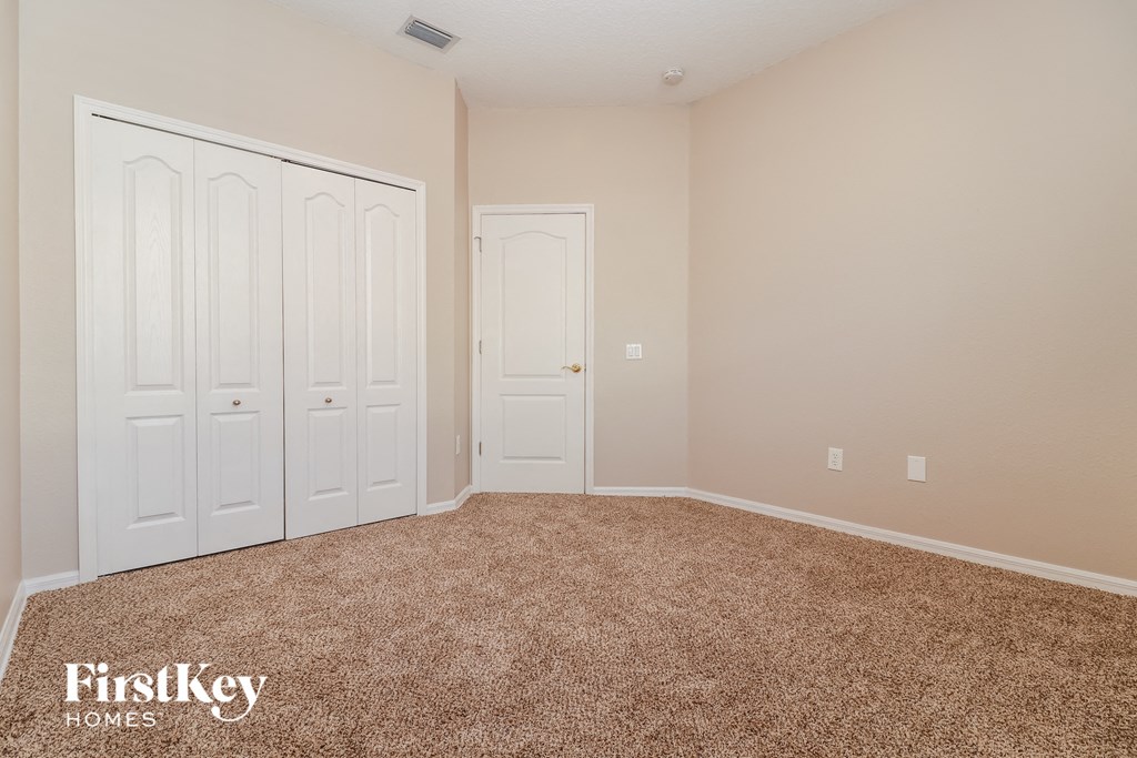 a bedroom with two doors and a carpeted floor
