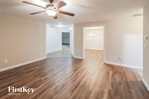 the living room and dining room with hardwood flooring and a ceiling fan