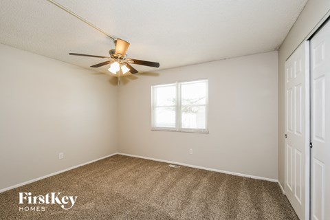 a bedroom with carpet and a ceiling fan