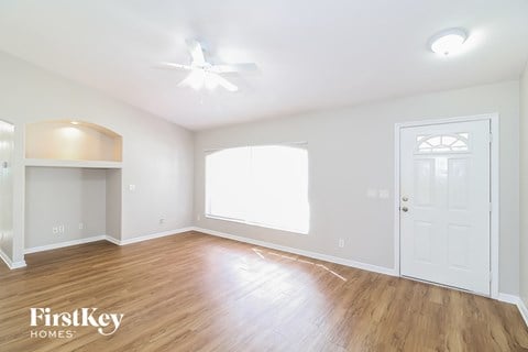 a living room with hardwood flooring and a white door