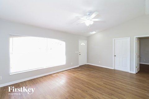 a living room with wood floors and a ceiling fan