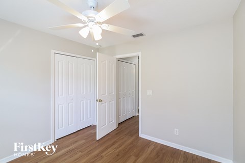 a bedroom with two closets and a ceiling fan
