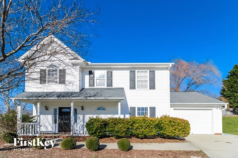 a white house with a porch and a blue sky