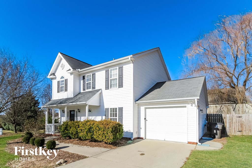 a white house with a white garage and a blue sky